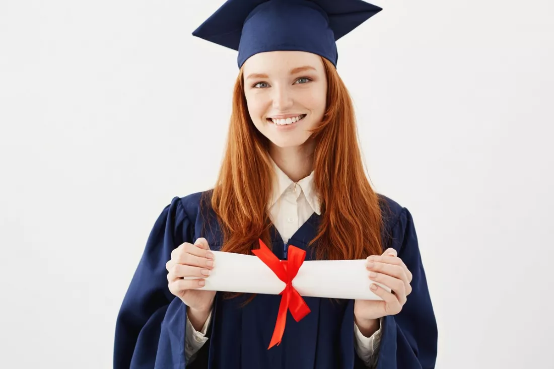Une jeune diplômée tient son diplôme